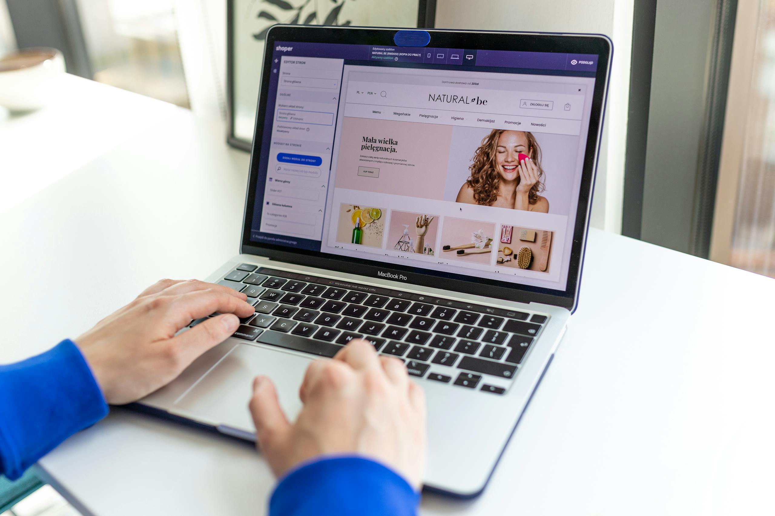 Mains tapant sur un ordinateur portable avec un site Web de commerce électronique ouvert, présentant des achats en ligne. Création d'une Boutique Shopify en cours