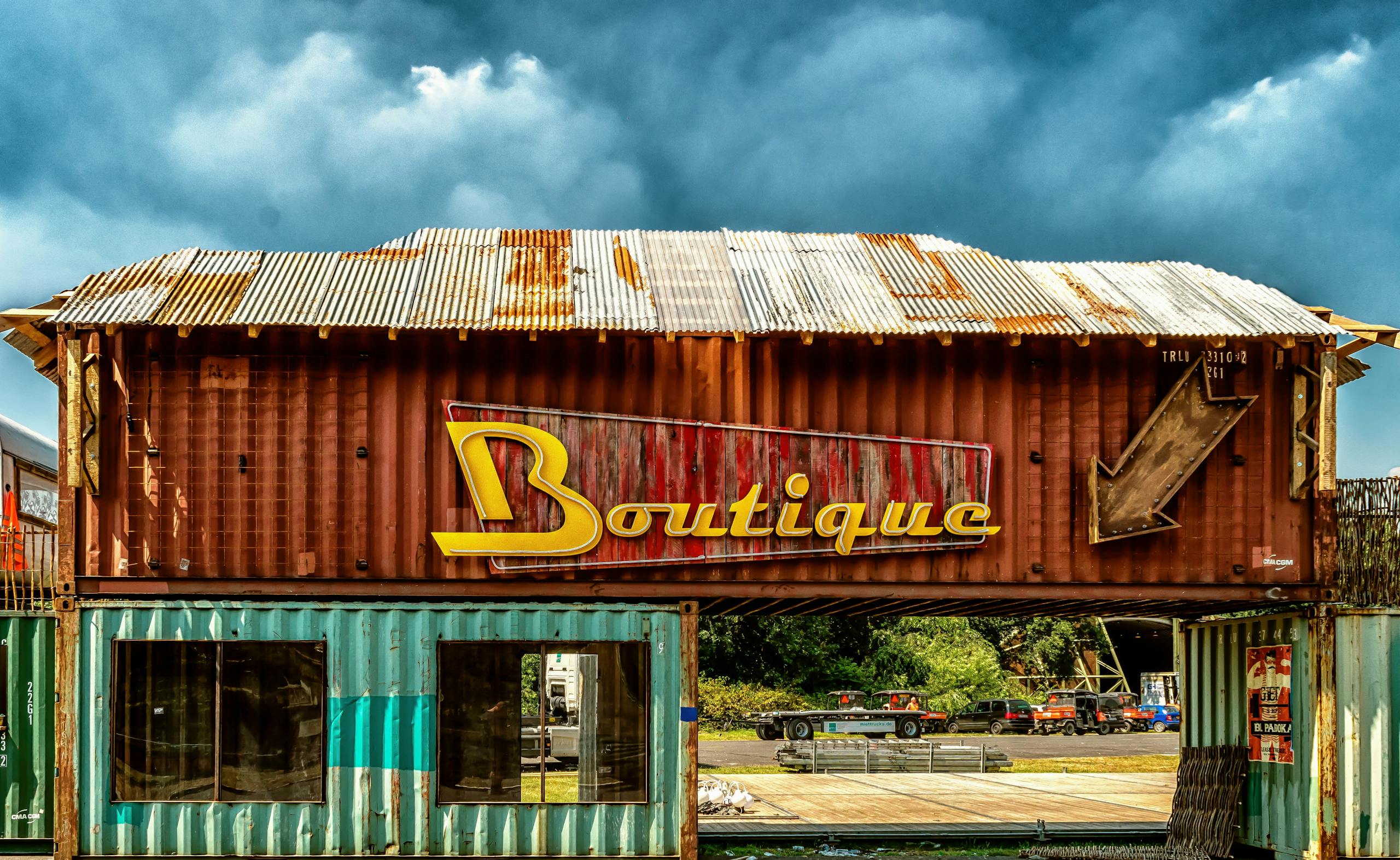 Panneau de boutique vintage sur un conteneur d'expédition rustique sous un ciel nuageux, à l'extérieur.