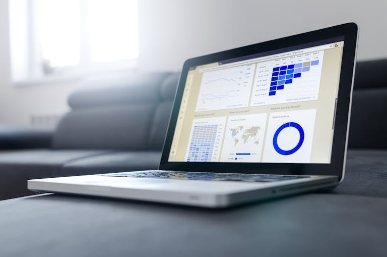 Ordinateur portable élégant présentant des analyses de données et des graphiques sur l'écran dans une pièce lumineuse. Audit et Optimisation SEO en cours